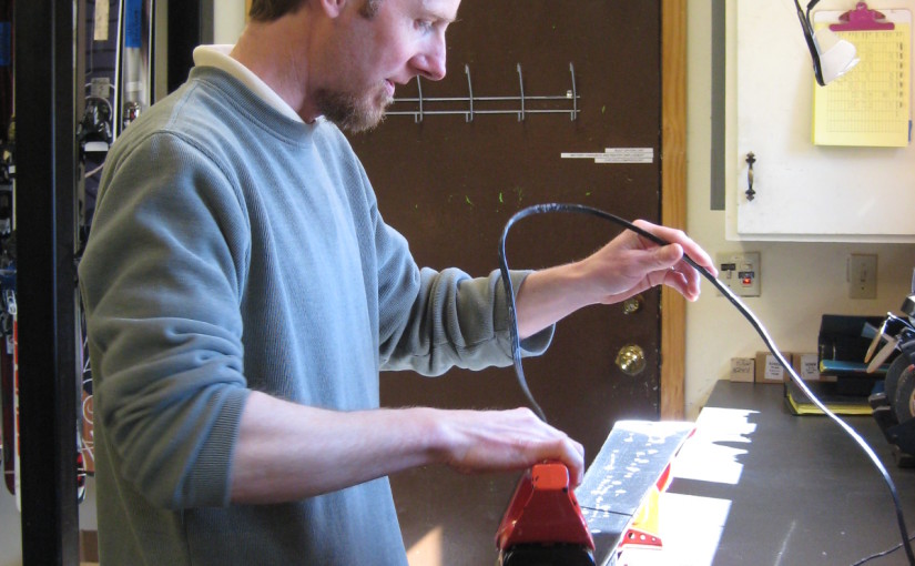 Andrew hot ironing in some ski wax on a pair of skis.